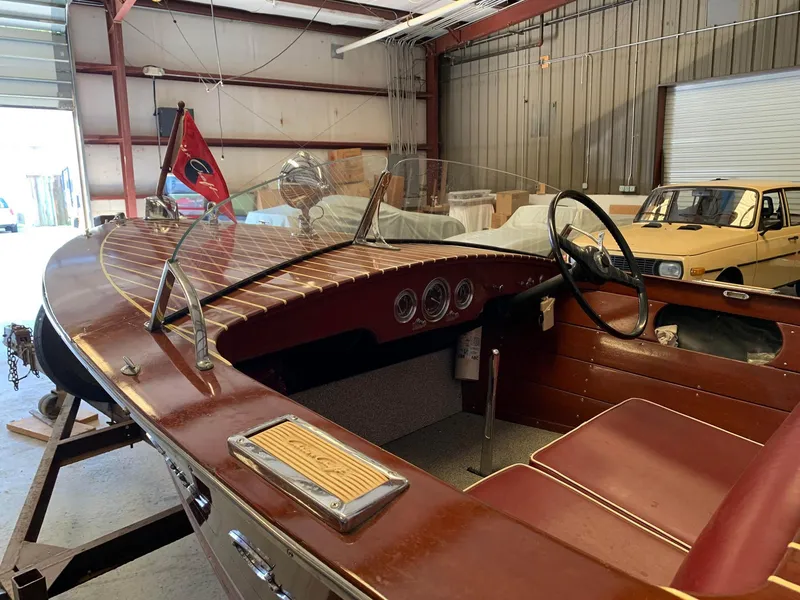 Slide: The Image of 1947 Chris-Craft 17 Runabout Deluxe in a garage, showcasing vintage wooden design and interior. - 11
