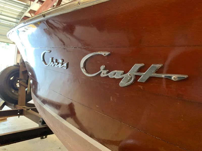 Slide: The Image of 1947 Chris-Craft 17 Runabout Deluxe boat with polished wood finish and chrome logo. - 12