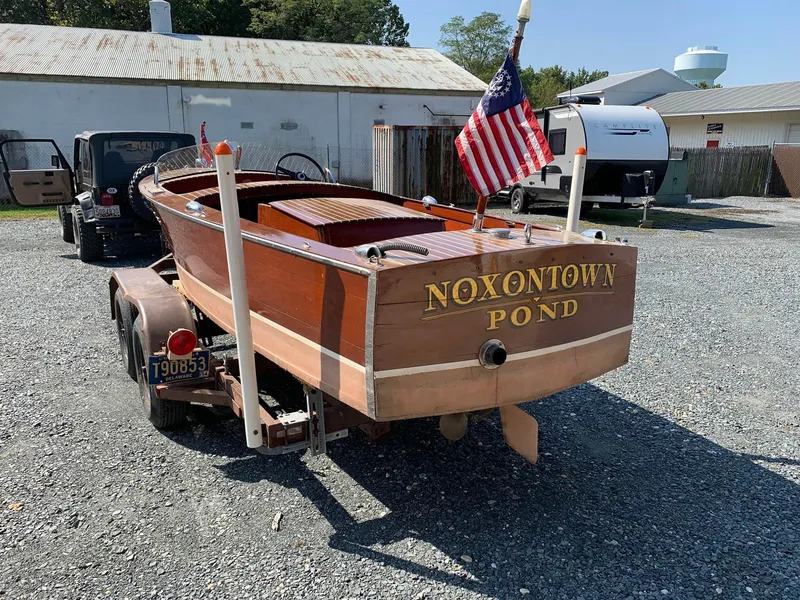 Slide: The Image of 1947 Chris-Craft 17 Runabout Deluxe boat on trailer with American flag, labeled "Noxontown Pond." - 2