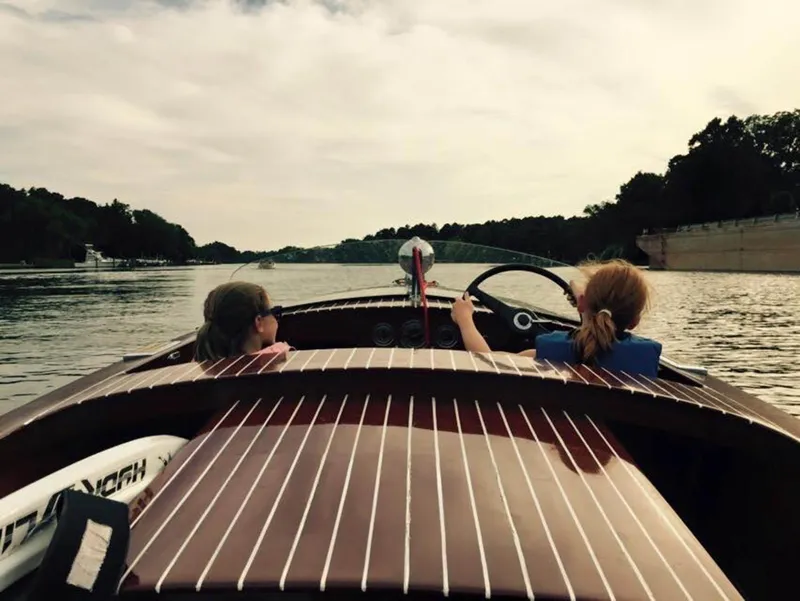 Slide: The Image of 1947 Chris-Craft 17 Runabout Deluxe on a serene lake with two passengers. - 27