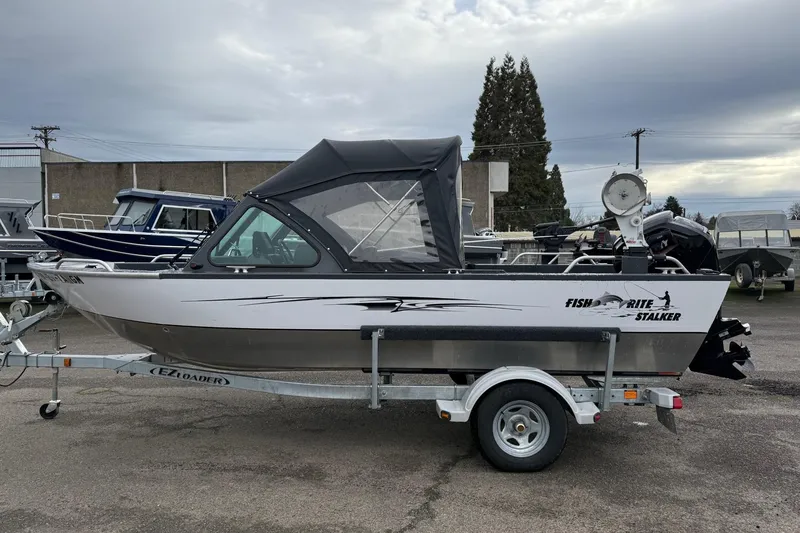 Slide: The Image of 2019 Fish Rite Stalker boat on trailer, parked outdoors under cloudy sky. - 26