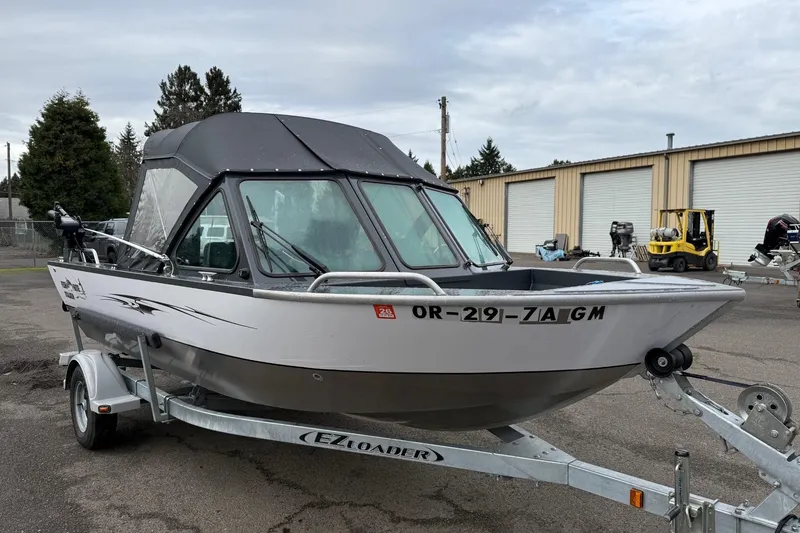 Slide: The Image of 2019 Fish Rite Stalker boat on trailer, parked outdoors near industrial buildings. - 30
