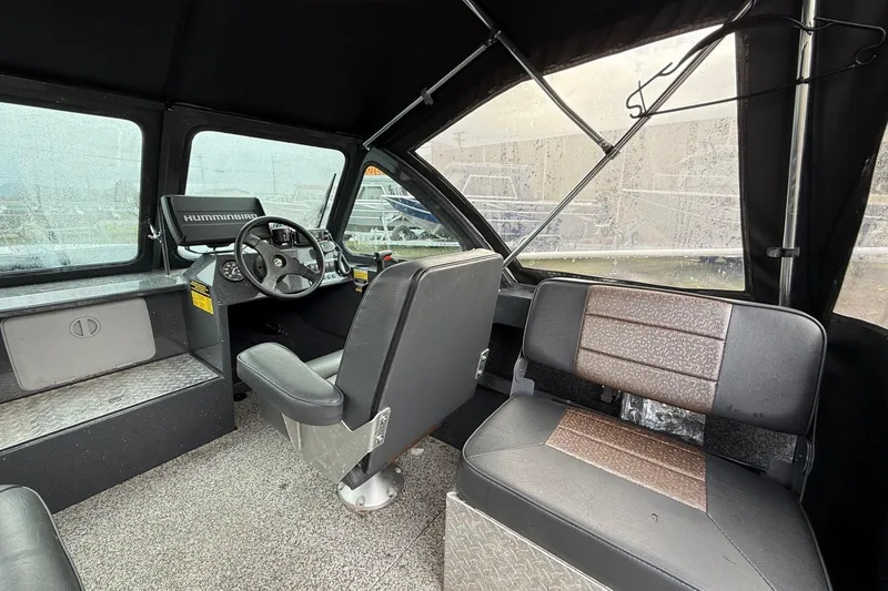 Slide: The Image of 2019 Fish Rite Stalker boat interior with steering wheel and seating. - 35
