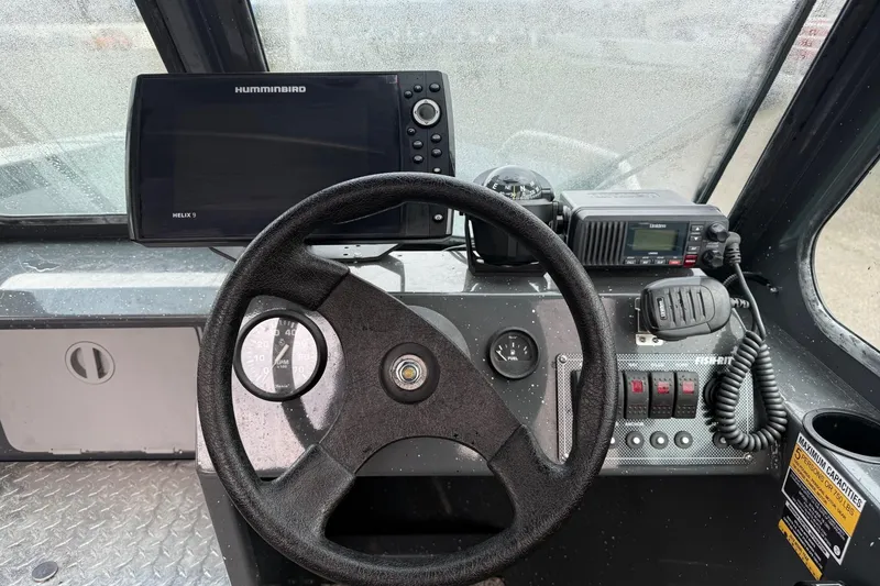 Slide: The Image of 2019 Fish Rite Stalker boat dashboard with steering wheel, Humminbird Helix 9, and communication equipment. - 44