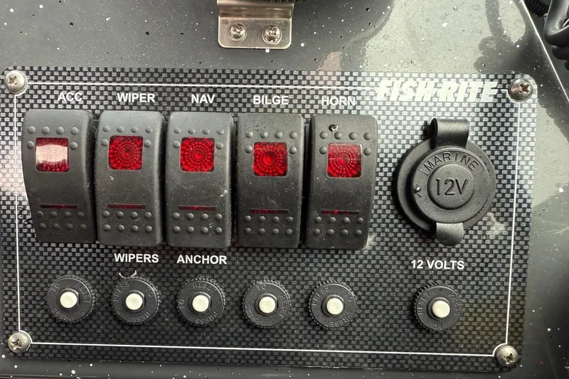 Slide: The Image of Control panel of a 2019 Fish Rite Stalker boat with switches and 12V outlet. - 47