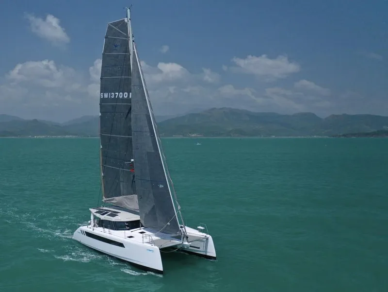Slide: The Image of 2026 Seawind 1370 catamaran sailing on turquoise waters under a clear blue sky. - 6
