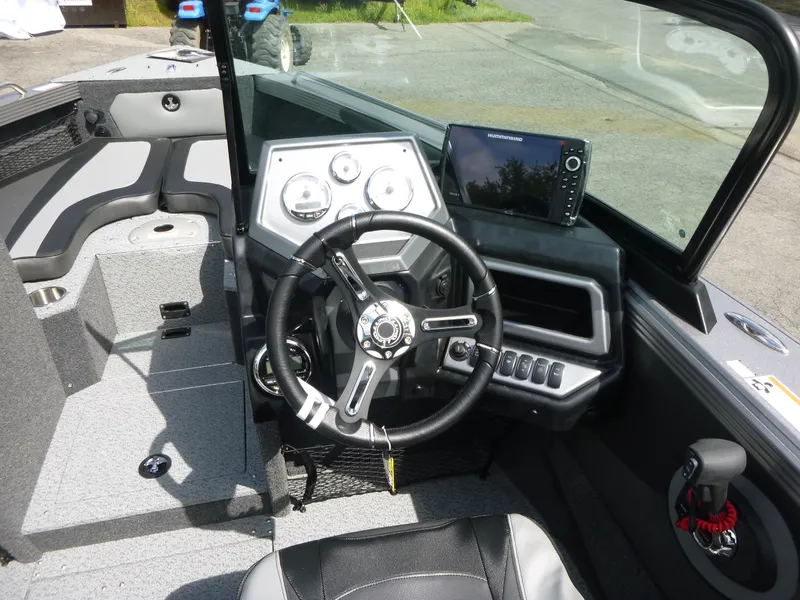 Slide: The Image of Interior of a 2021 Lund 1975 Tyee boat with steering wheel and control panel. - 13