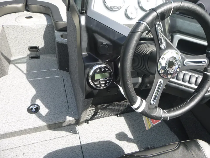 Slide: The Image of Interior of a 2021 Lund 1975 Tyee boat, featuring steering wheel and dashboard controls. - 14