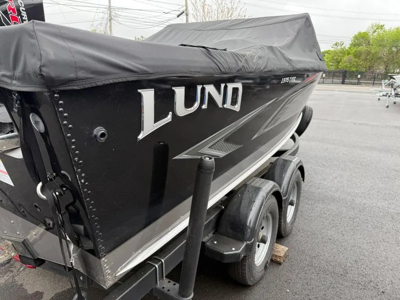 Slide: The Image of Lund 1975 Tyee boat on trailer, covered, parked outdoors, 2021 model. - 23