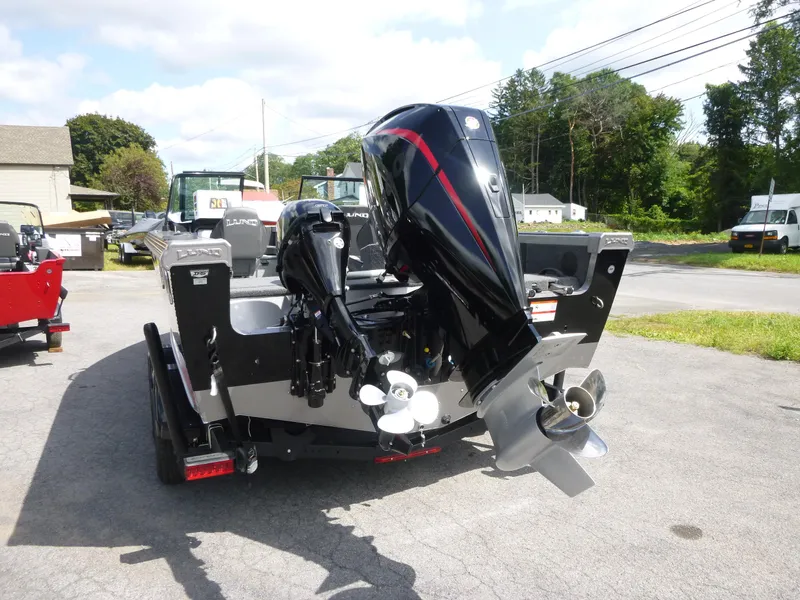 Slide: The Image of 2021 Lund 1975 Tyee boat with powerful outboard motor, parked outdoors. - 26