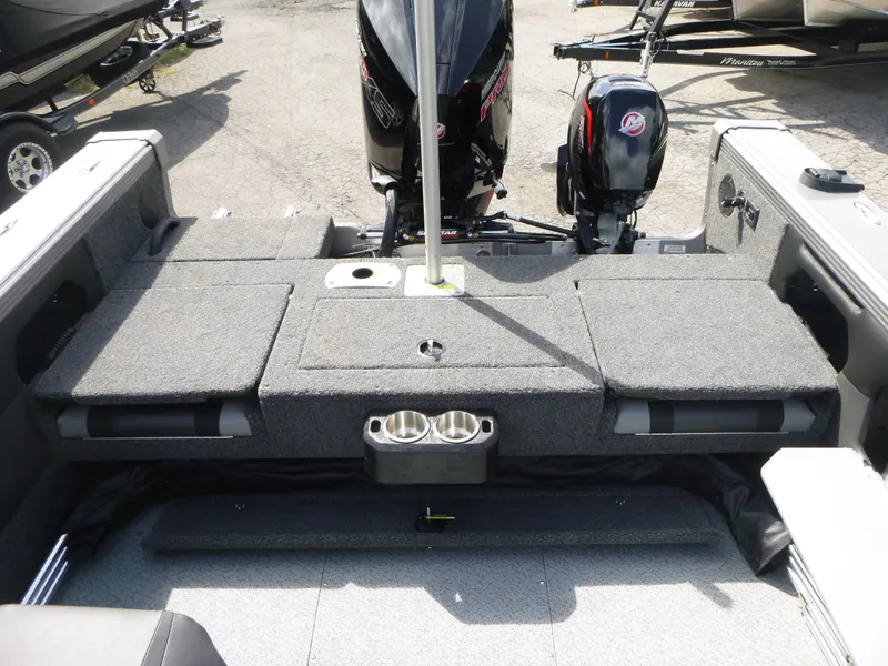 Slide: The Image of 2021 Lund 1975 Tyee boat interior with motor, featuring gray carpeted seating and cup holders. - 31