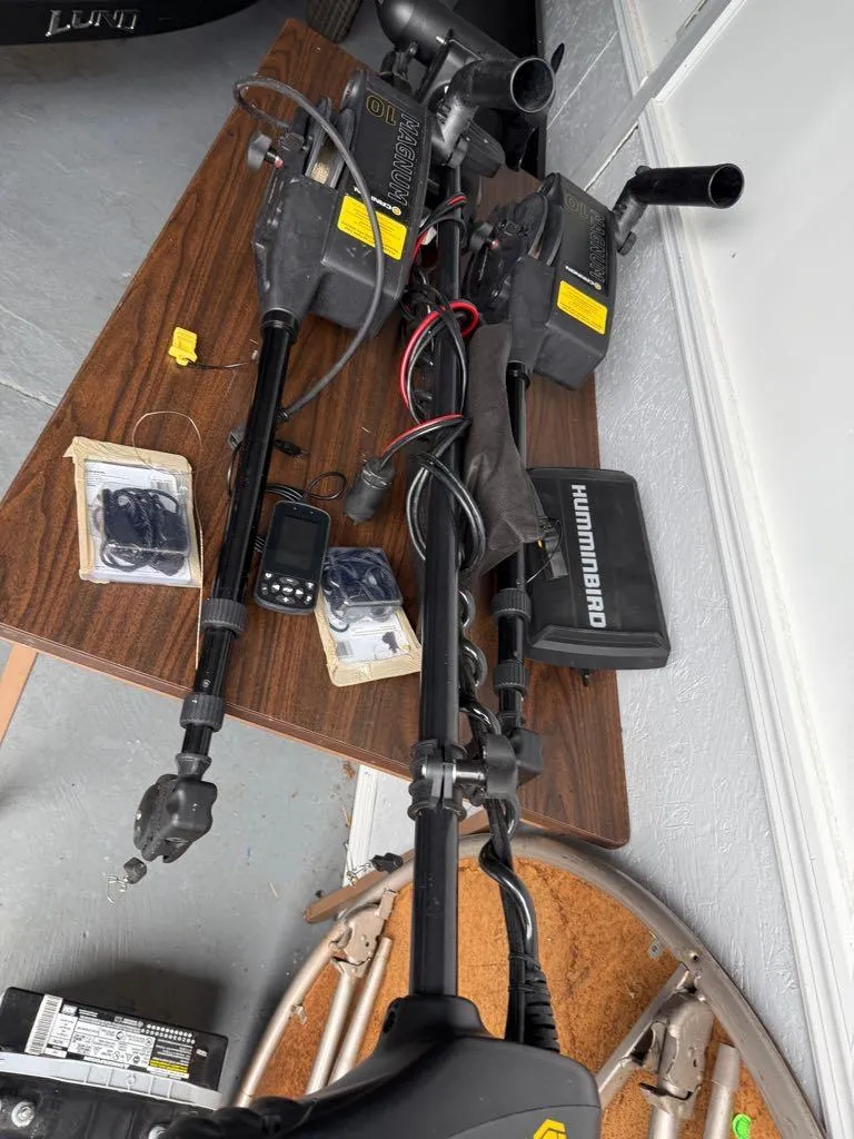 Slide: The Image of Fishing equipment and electronics on a table, including Humminbird devices, for a 2021 Lund 1975 Tyee. - 41