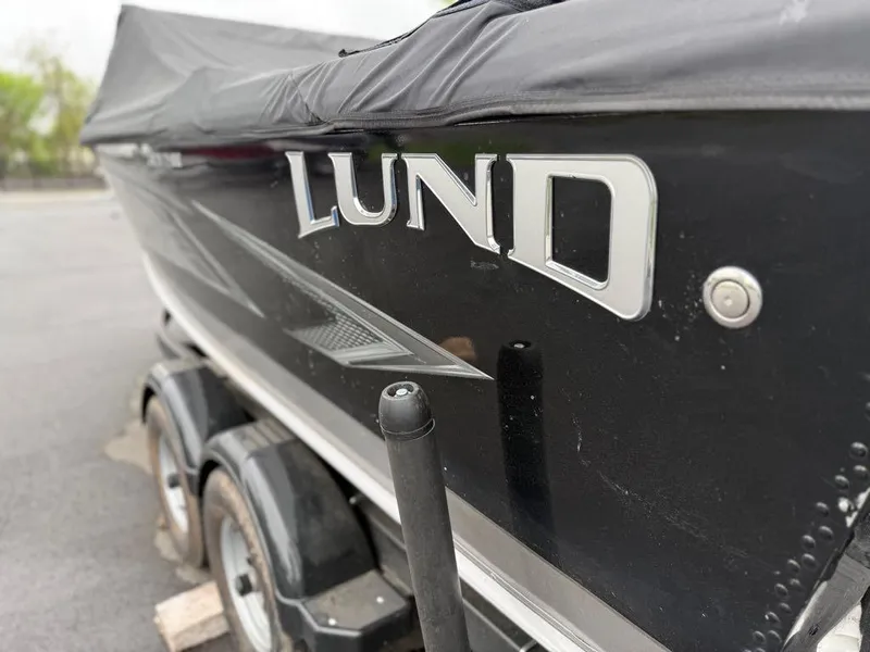 Slide: The Image of Lund 1975 Tyee boat, 2021 model, black exterior with cover, on trailer. - 43