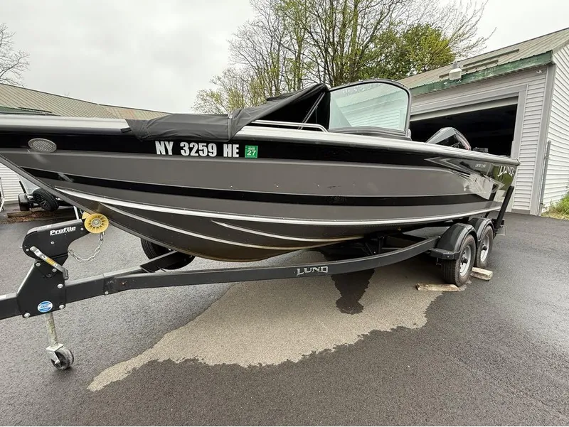 Slide: The Image of 2021 Lund 1975 Tyee boat on trailer, parked outside a garage. - 45