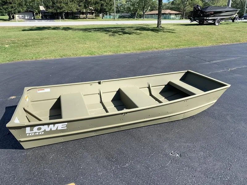 Slide: The Image of 2024 Lowe L1040 Jon boat on asphalt, surrounded by grass and trees. - 3