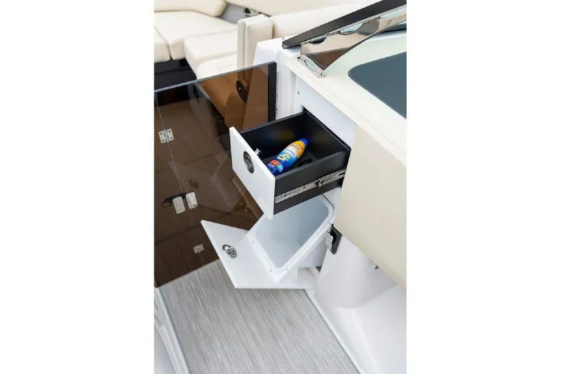 Slide: The Image of 2023 Regal 2800 Bowrider interior storage compartment with open drawers and sunscreen bottle. - 10