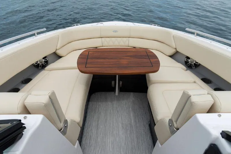 Slide: The Image of 2023 Regal 2800 Bowrider interior with elegant seating and wooden table on water. - 4