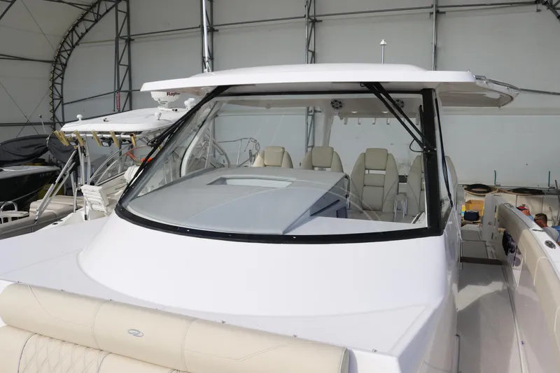 Slide: The Image of 2023 Regal 38 SAV boat with sleek design in a covered marina. - 12