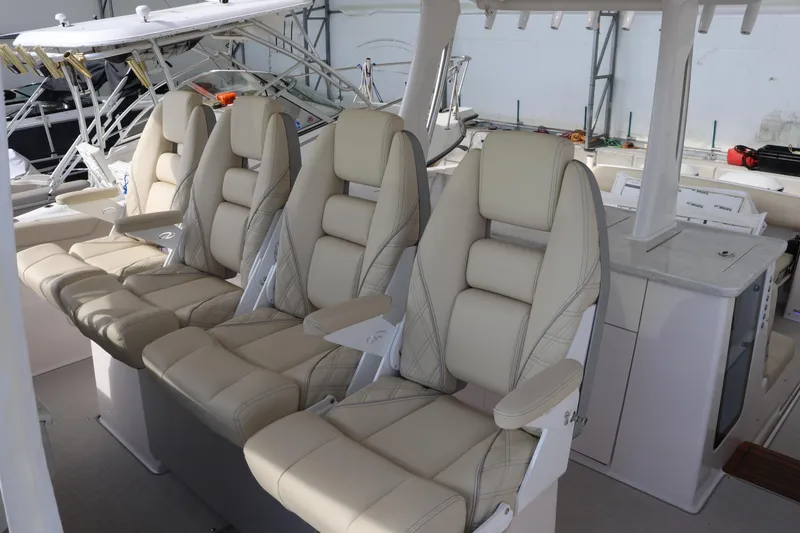 Slide: The Image of Luxurious seating on 2023 Regal 38 SAV boat, featuring plush beige leather chairs. - 13