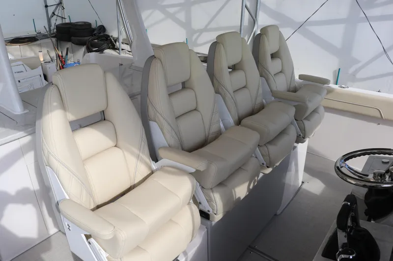 Slide: The Image of Luxurious seating on 2023 Regal 38 SAV boat, featuring four plush, cream-colored captain's chairs. - 14