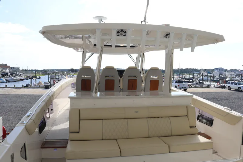 Slide: The Image of 2023 Regal 38 SAV yacht with spacious seating and modern design at a marina. - 16