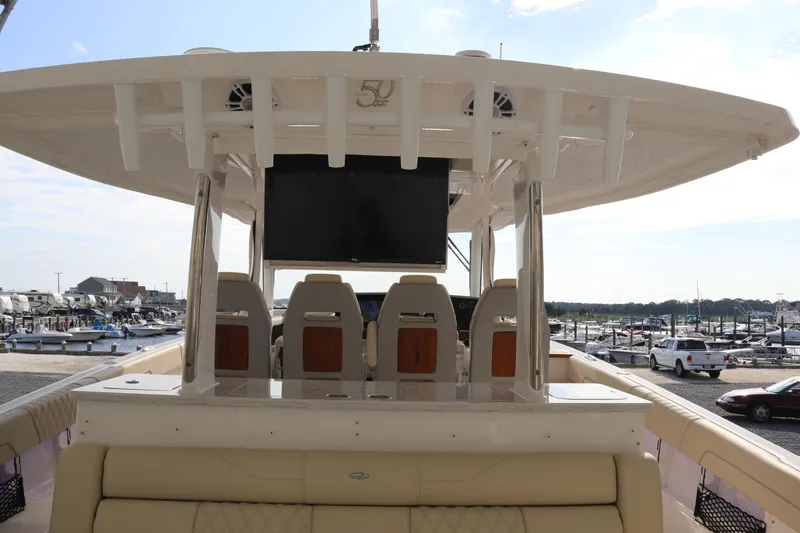 Slide: The Image of 2023 Regal 38 SAV boat with spacious seating and modern helm at a marina. - 17