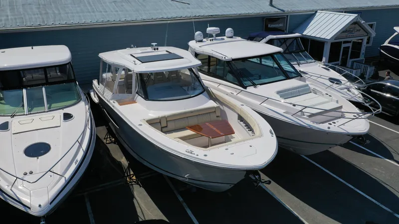 Slide: The Image of 2023 Regal 38 SAV boat displayed in a marina, surrounded by other luxury vessels. - 2