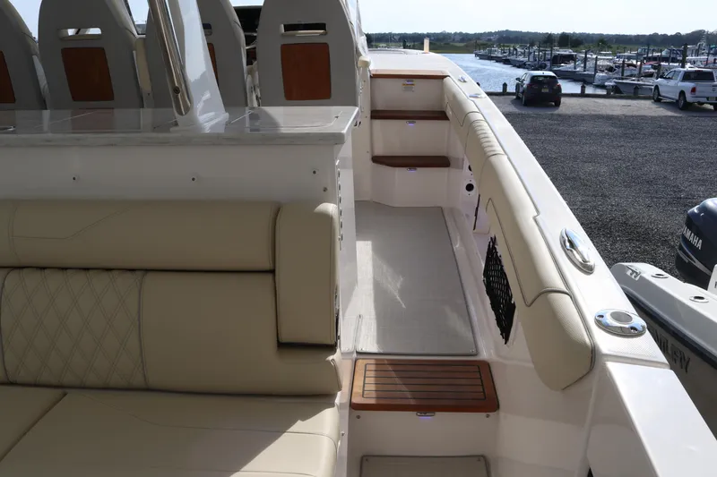 Slide: The Image of 2023 Regal 38 SAV boat interior with beige seating and dockside view. - 26