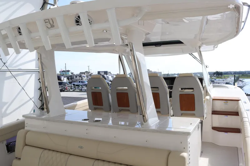 Slide: The Image of 2023 Regal 38 SAV boat interior with seating and helm, docked at marina. - 27