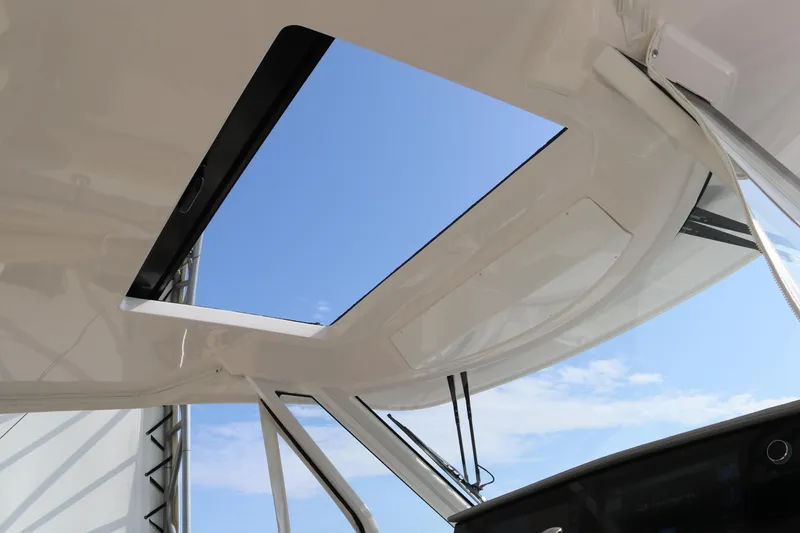 Slide: The Image of 2023 Regal 38 SAV boat with open sunroof, showcasing clear blue sky. - 29