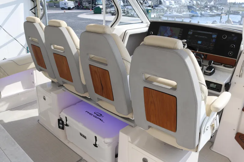 Slide: The Image of 2023 Regal 38 SAV boat interior with four cushioned seats and modern dashboard. - 30
