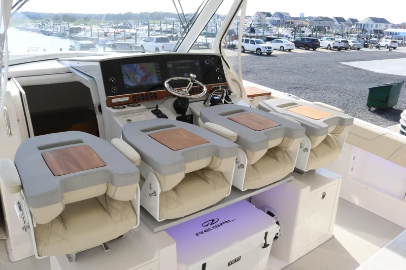 Slide: The Image of 2023 Regal 38 SAV boat helm with four cushioned seats and modern dashboard. - 32