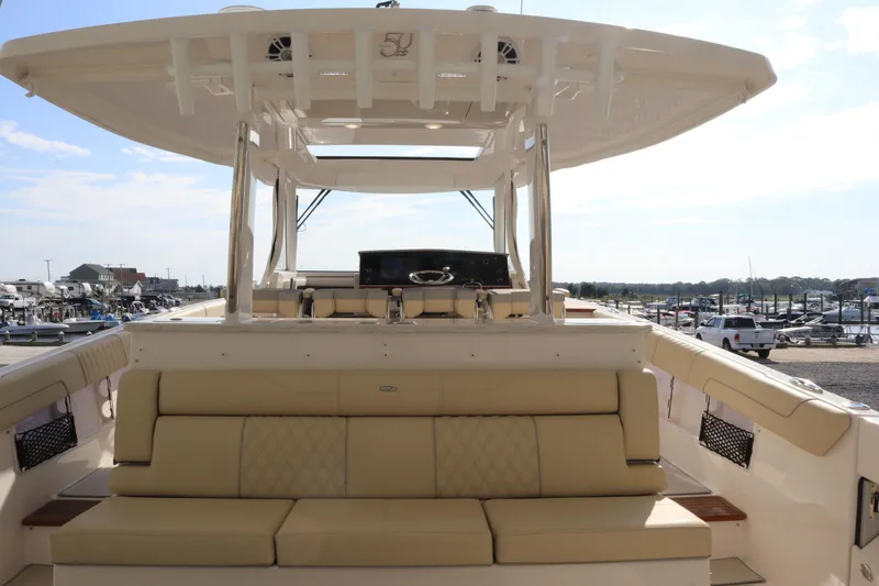 Slide: The Image of 2023 Regal 38 SAV luxury boat with spacious seating and modern design at a marina. - 36