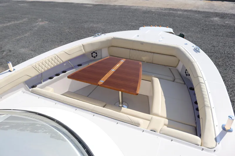 Slide: The Image of 2023 Regal 38 SAV boat interior with cushioned seating and wooden table. - 44