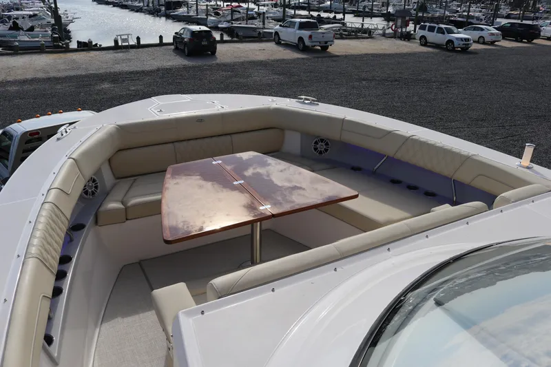 Slide: The Image of 2023 Regal 38 SAV boat with spacious seating and wooden table on deck. - 9