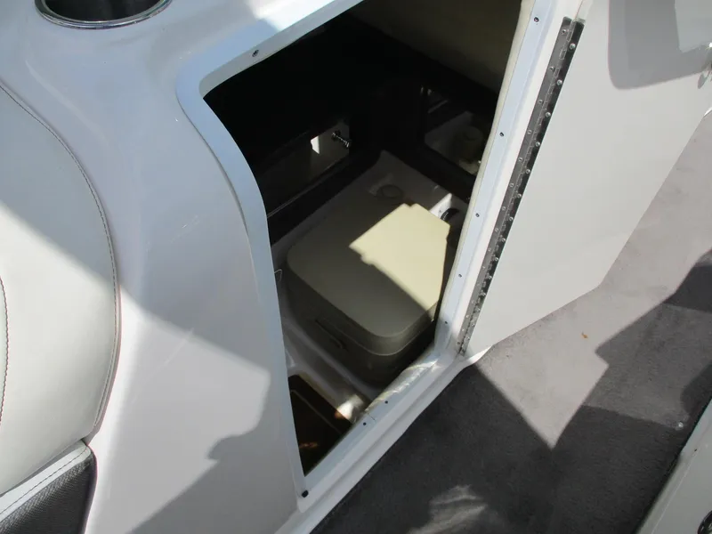 Slide: The Image of 2013 Regal 24 FasDeck RX boat interior storage compartment with portable toilet. - 13