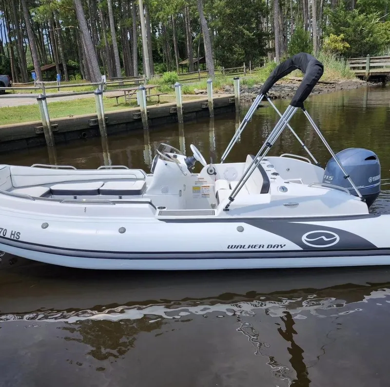 The Image of 2025 Walker Bay Generation 525 boat docked in a serene lakeside setting. - 0