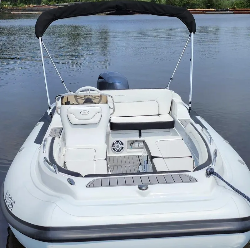 Slide: The Image of 2025 Walker Bay Generation 525 boat with seating and canopy on calm water. - 4