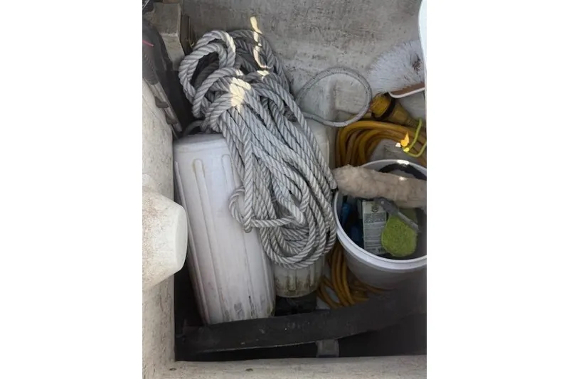 Slide: The Image of Storage compartment on a 2002 Beneteau First 36.7 with ropes, fender, and cleaning supplies. - 15