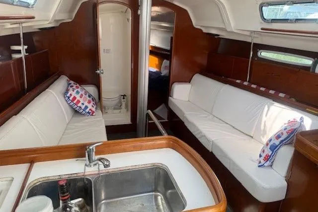 Slide: The Image of Interior of 2002 Beneteau First 36.7 sailboat with white seating and wooden finishes. - 19