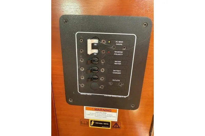 Slide: The Image of Electrical panel on a 2002 Beneteau First 36.7 sailboat, featuring various switches and warnings. - 24