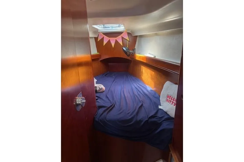 Slide: The Image of Cozy cabin interior of 2002 Beneteau First 36.7 sailboat with blue bedding and decorative bunting. - 25