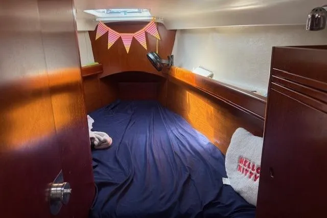 Slide: The Image of Cozy cabin interior of 2002 Beneteau First 36.7 sailboat with blue bedding and decorative bunting. - 26