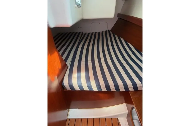 Slide: The Image of Interior cabin of 2002 Beneteau First 36.7 with striped mattress and wooden finish. - 28