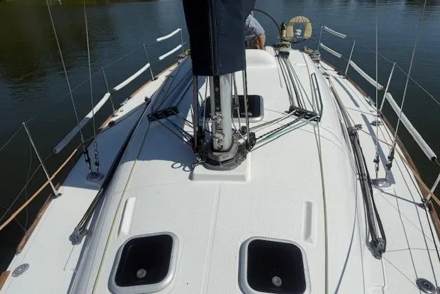 Slide: The Image of 2002 Beneteau First 36.7 sailboat deck with rigging and hatches, on calm water. - 7