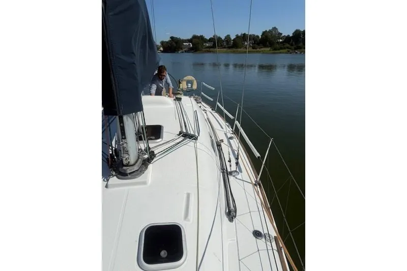 Slide: The Image of Sailboat Beneteau First 36.7, 2002 model, on calm water with a person on deck. - 9