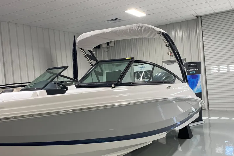 Slide: The Image of 2022 Regal 21 OBX boat in showroom, featuring sleek design and modern canopy. - 1
