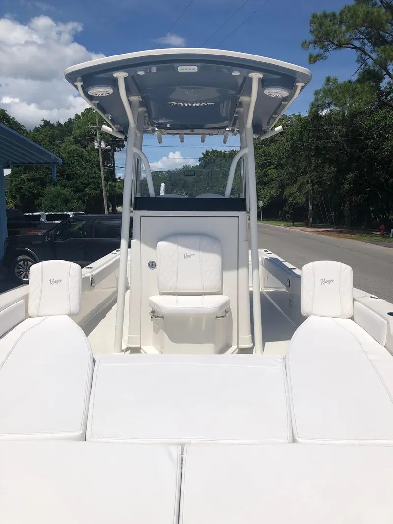 Slide: The Image of 2025 Ranger 2660 boat with white seating and T-top, parked on a sunny street. - 14
