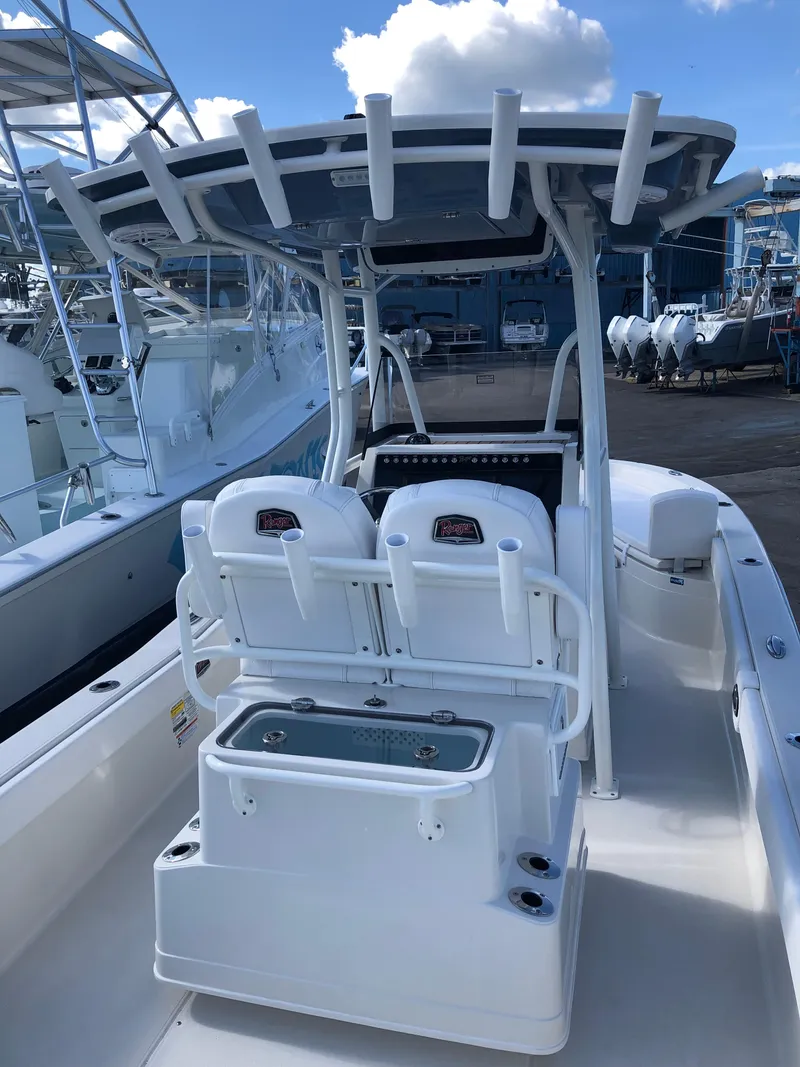 Slide: The Image of 2025 Ranger 2660 boat with dual seats and center console, docked under a blue sky. - 15