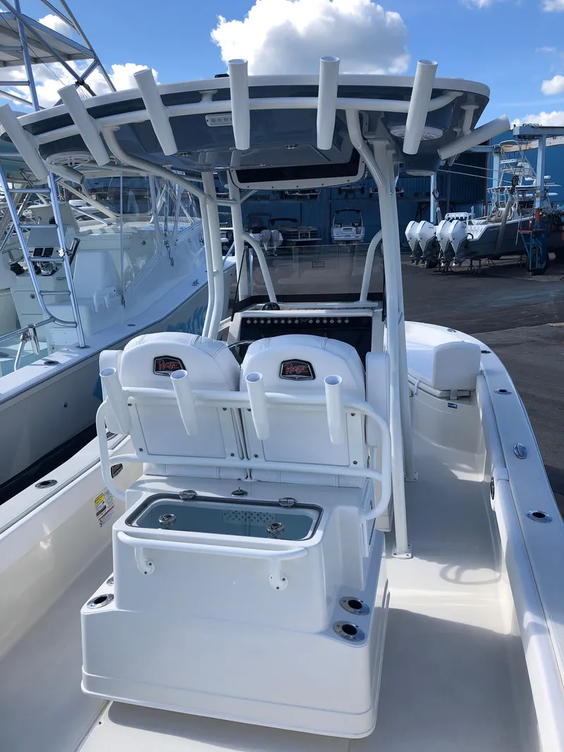 Slide: The Image of 2025 Ranger 2660 boat with dual seats and T-top in marina setting. - 16